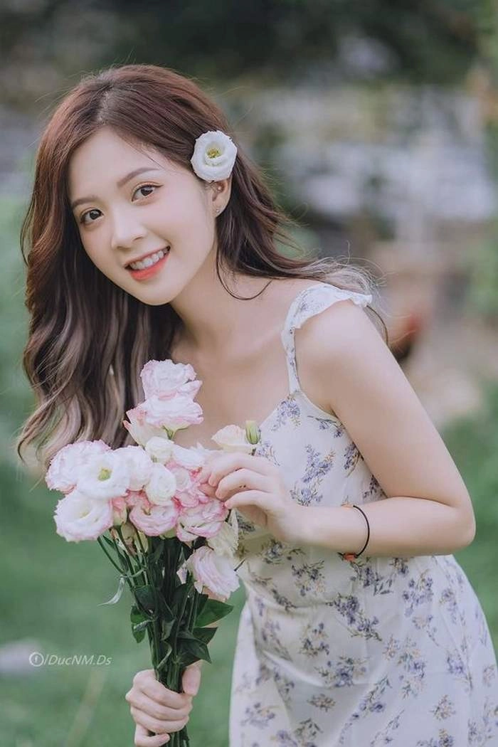 Cô gái cầm hoa đẹp làm nổi bật vẻ duyên dáng và thu hút